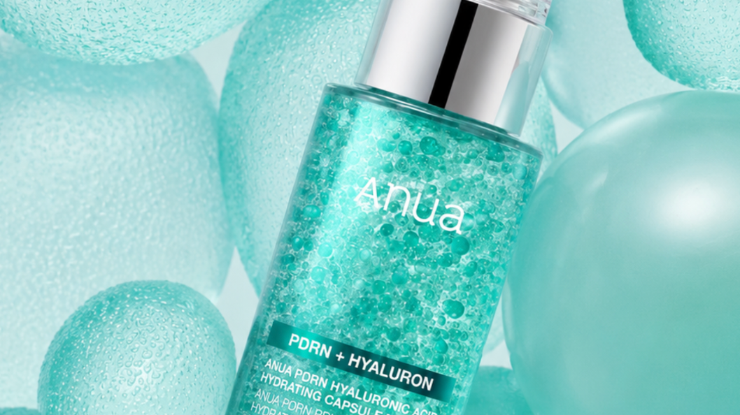 Anua PDRN + Hyaluron Hydrating Capsule Serum i tirkosblå förpackning omgiven av vattenpärlor