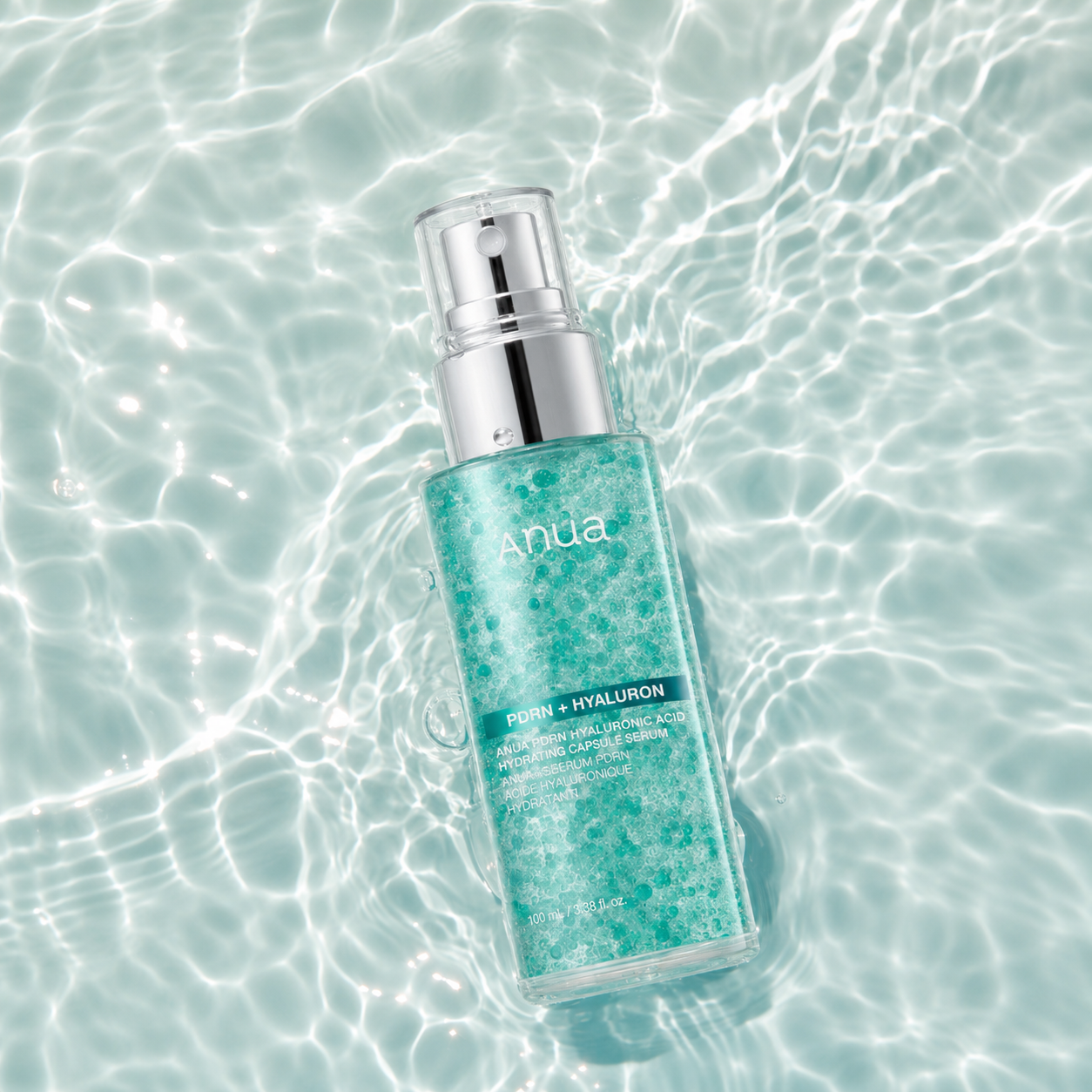 Anua PDRN Hyaluronic Acid Hydrating Capsule Serum 100ml floating in clear water, deeply hydrating serum with PDRN and hyaluronic acid for plump and radiant skin.